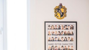 A room with a framed Harry Potter characters poster, a round table, and two chairs. - Harry Potter self check-in studio / Nespresso / Ne (Saint-Gilles)