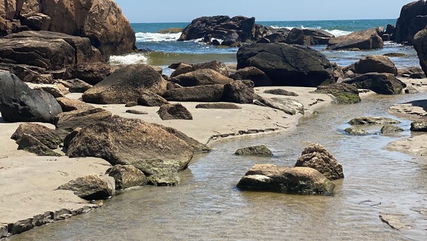 A rocky beach with clear water and large boulders. - Coastal Farmhouse Retreat in Little Compton, RI – Your Perfect Seaside Getaway (Little Compton)