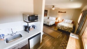A compact hotel room with a kitchenette, two beds, a ceiling fan, and a small bathroom. - Relaxing Getaway in our Double Kitchenette at Lodges of Oak Creek! (Oak Creek)