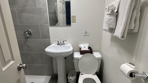 A bathroom with a bathtub, sink, toilet, and a towel rack.