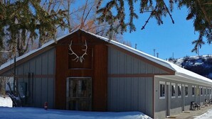 A large building with a wooden facade and a metal roof, featuring a prominent antler display above the entrance. - Relaxing Getaway in our Homespun Double Kitchenette at Lodges of Oak Creek! (Oak Creek)