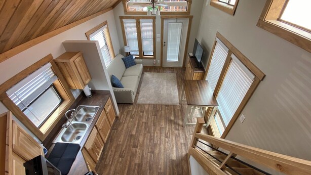 A compact, multi-level cabin with a kitchen, dining area, and living space.