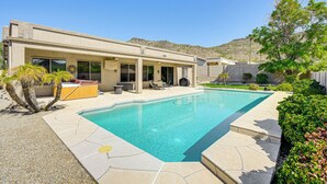 Ein modernes Haus mit Swimmingpool, Terrassenmöbeln und Whirlpool.