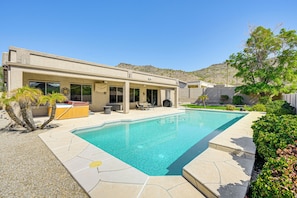 Ein modernes Haus mit Swimmingpool, Terrassenmöbeln und Whirlpool.