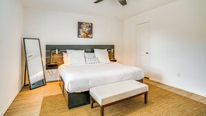 Un dormitorio con cama, mesita de noche y ventilador de techo.
