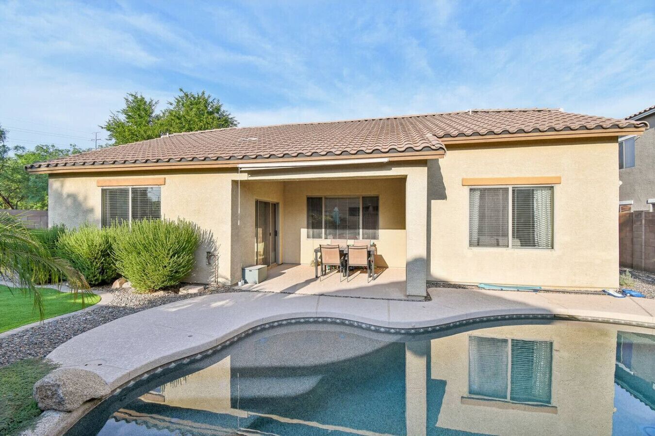 A two-story house with a swimming pool in front.