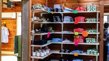 Un intérieur en bois avec un portant à vêtements où sont présentés divers vêtements pliés.