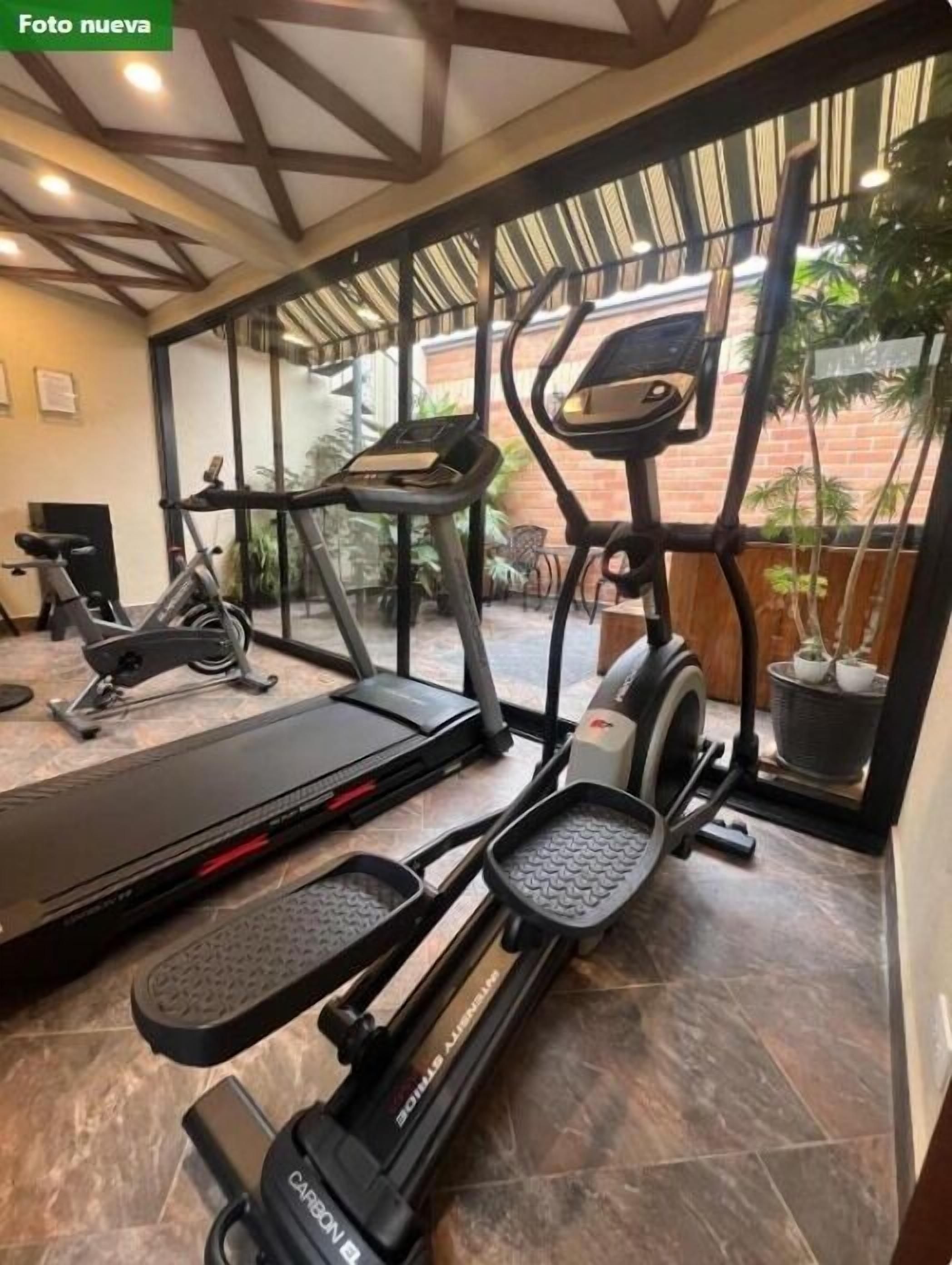 Une salle de sport équipée de tapis de course, d’appareils elliptiques et de vélos d’appartement.