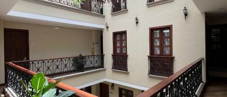 A multi-level atrium with a central open space, wooden railings, and a chandelier.