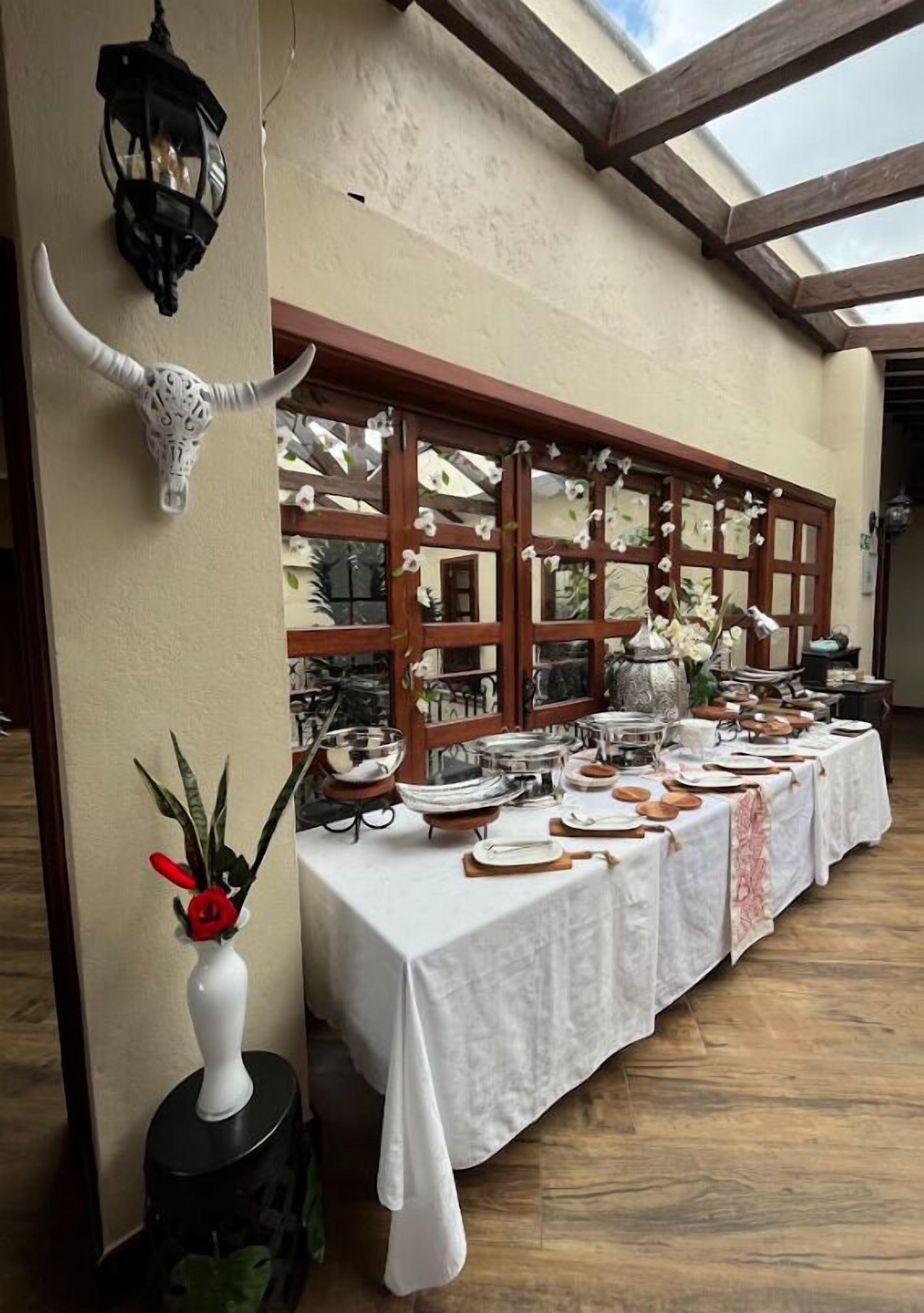 A buffet setup with a variety of dishes and a decorative bull skull on the wall.