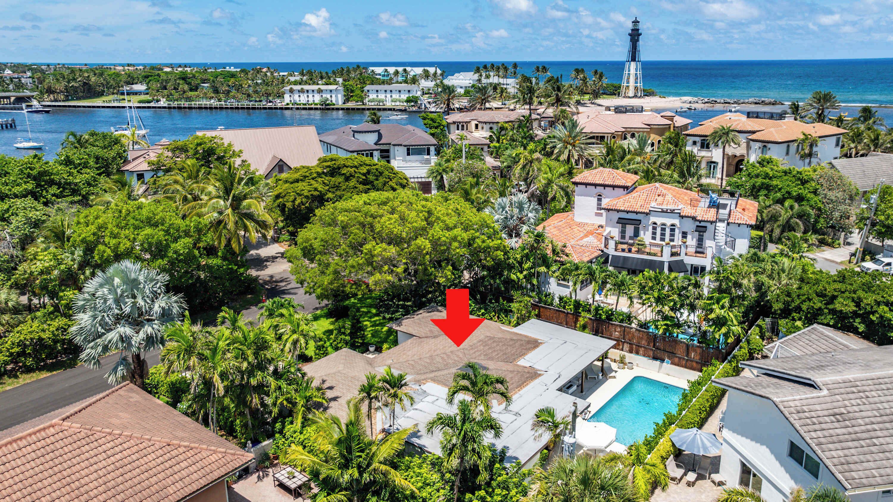 Un área residencial costera con varias casas, un faro y un puerto deportivo.