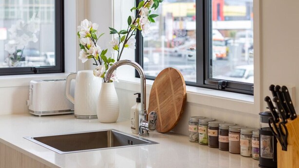 A modern kitchen with a stainless steel sink, white appliances, and a window view. - Luxurious Studio: Prime location, City Centre (Christchurch)
