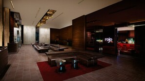 A modern lobby with seating areas, a bar, and a visible 'rojo' sign. - 34th Floor High rise with 180° Strip Views + Open Balcony - No Resort Fees (Las Vegas)