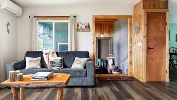A living room with a sofa, coffee table, and a wooden door.