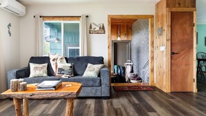 Un salon avec un canapé, une table basse et une porte en bois.