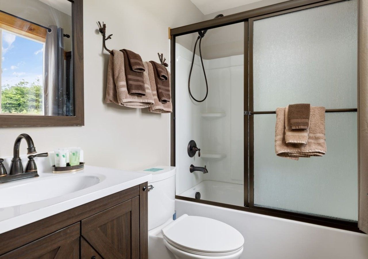 Une salle de bain avec douche, toilettes et lavabo.