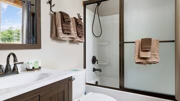 A bathroom with a shower, toilet, and sink.