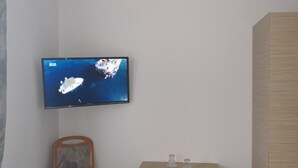 A television mounted on a wall displaying an aerial view of a coastal area with boats. - FREE PARKING, FREE BREAKFAST, only 15 minutes to City Center (Budapest)