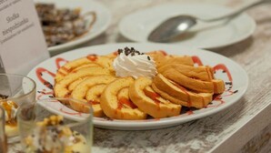 A plate of sliced pastries with whipped cream and a drizzle of sauce. - FREE PARKING, FREE BREAKFAST, only 15 minutes to City Center (Budapest)