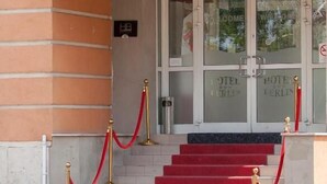 The entrance to Hotel Berlin with a sign above the door, a set of red carpeted stairs, and a red rope barrier. - FREE PARKING, FREE BREAKFAST, only 15 minutes to City Center (Budapest)