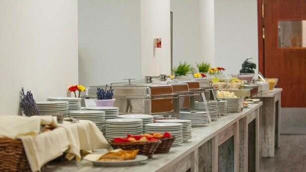 A buffet setup with multiple serving stations, plates, and baskets of food. - FREE PARKING, FREE BREAKFAST, only 15 minutes to City Center (Budapest)