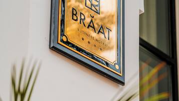 Una placa con el nombre "BRAAT BUSINESS HOTEL" en la pared de un edificio.
