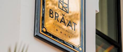 Una targa con su scritto 'BRAAT BUSINESS HOTEL' su una parete dell'edificio.