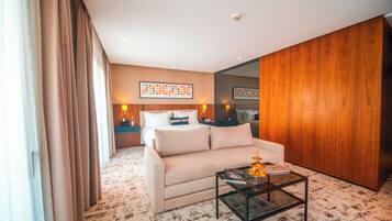 Una habitación de hotel moderna con un sofá, una mesita de centro y un espejo grande.