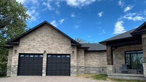 A two-story house with a stone facade and a large garage.