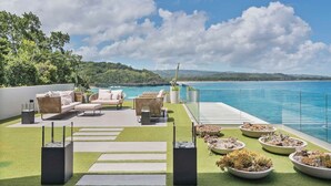A rooftop terrace with outdoor furniture, a pool, and a view of the ocean. - Gorgeous Beach House Perched Right Over the Ocean (Samaná)