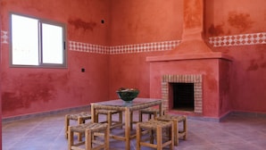 A room with a tiled floor, a table with four chairs, a bowl on the table, and a fireplace. - Land of dreams (Nekob)