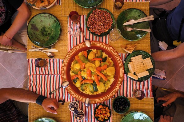 A dining table with various dishes, utensils, and a striped tablecloth. - Land of dreams (Nekob)