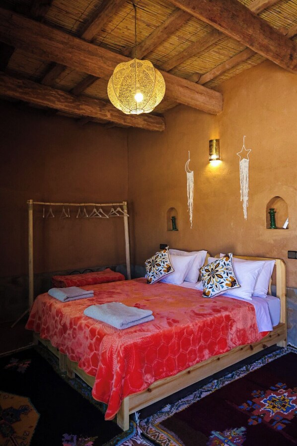 A cozy bedroom with a four-poster bed, a hanging light fixture, and wall-mounted decor. - Land of dreams (Nekob)