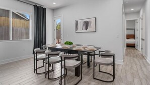 Un coin repas comprenant une table rectangulaire, six chaises et une plante servant de centre de table.