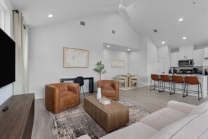 Relax in this stylish living room with a large flat-screen TV, comfortable sofa, and office chair.