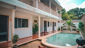 A residential building with a swimming pool, a covered patio, and a garden area with various plants. - Hotel del Parque (Valladolid)