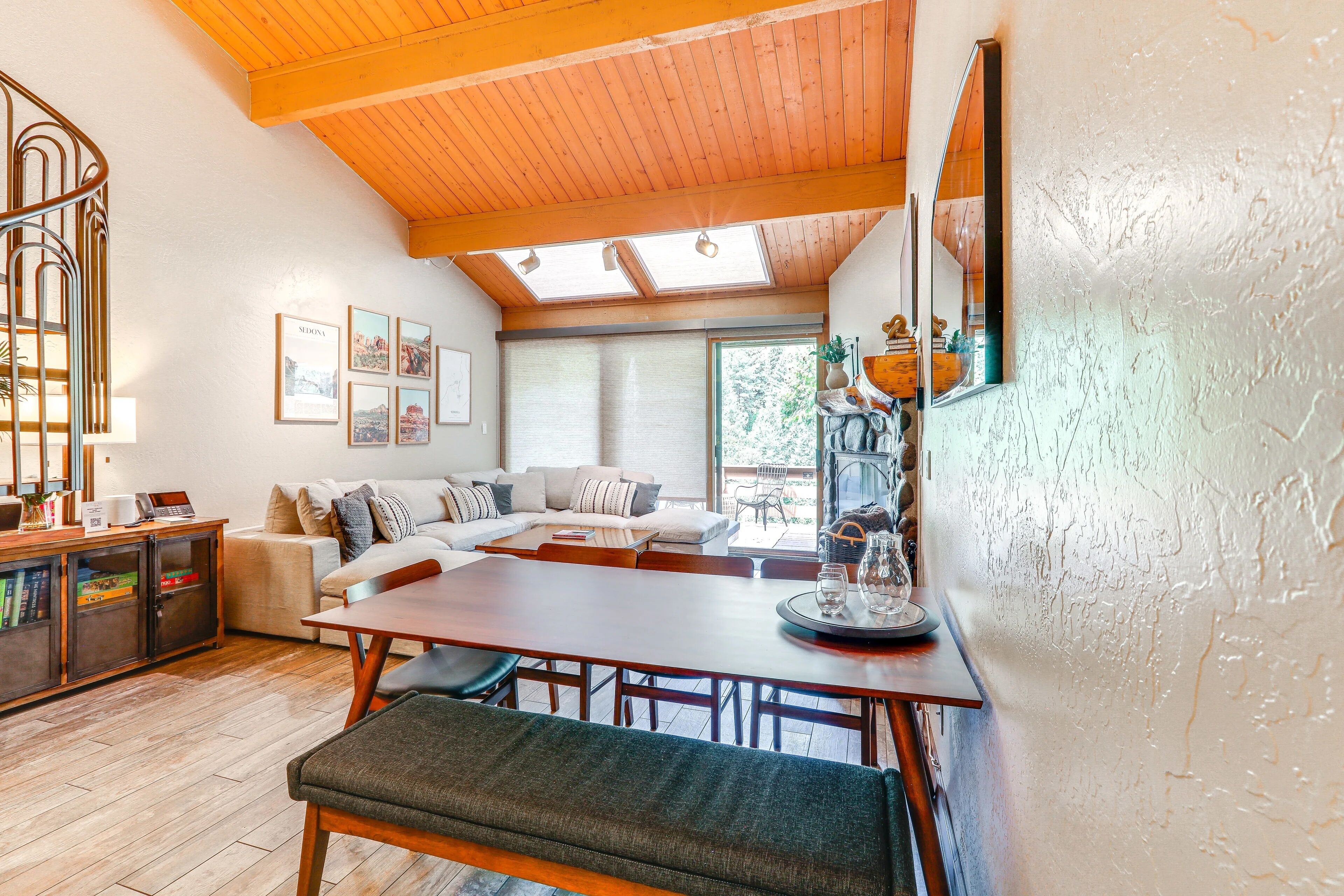 A cozy living area with a wooden ceiling, a dining table, and a sofa.