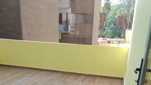 Un balcon avec un plancher en bois et des murs jaunes.