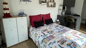 Un dormitorio con cama, escritorio y kitchenette.