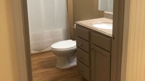 A small bathroom with a toilet, a sink, and a mirror.