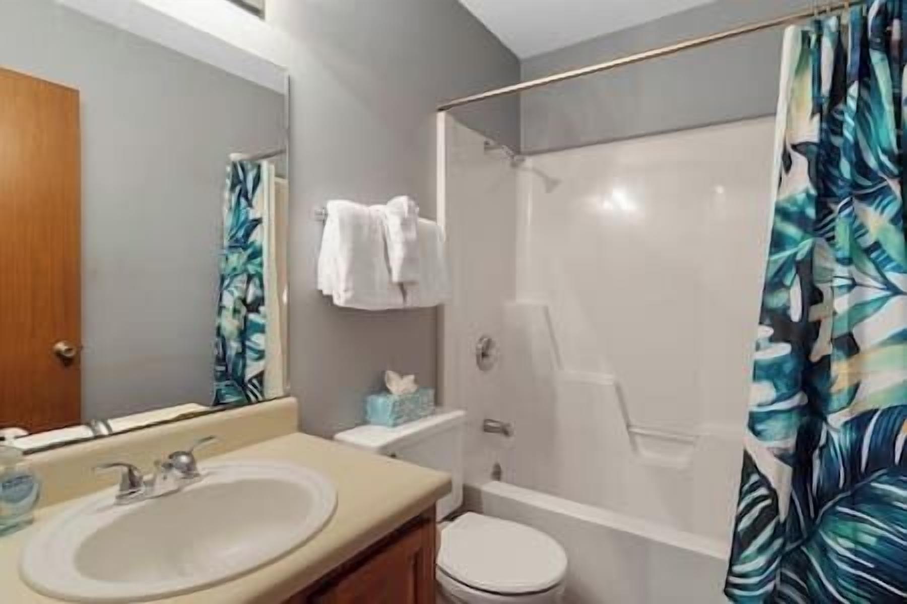 Een badkamer met een wastafel, toilet en douche.