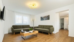 A modern living room with two sofas, a coffee table, and a painting on the wall. - Lux Suites Leipzig Luxury Apartment (Leipzig)