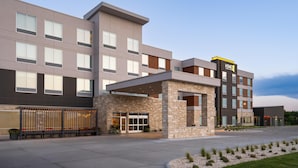 A modern hotel with a stone facade, multiple windows, and a covered entrance. - Home2 Suites By Hilton Kearney (Kearney)