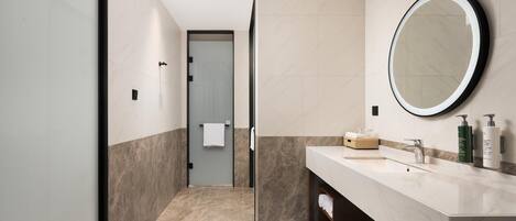 A modern bathroom with a large mirror, a sink, and a towel rack.