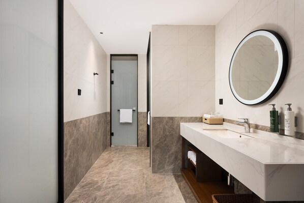 A modern bathroom with a large mirror, a sink, and a towel rack. - Hilton Garden Inn Guiyang Gui'An New Area (Guiyang)