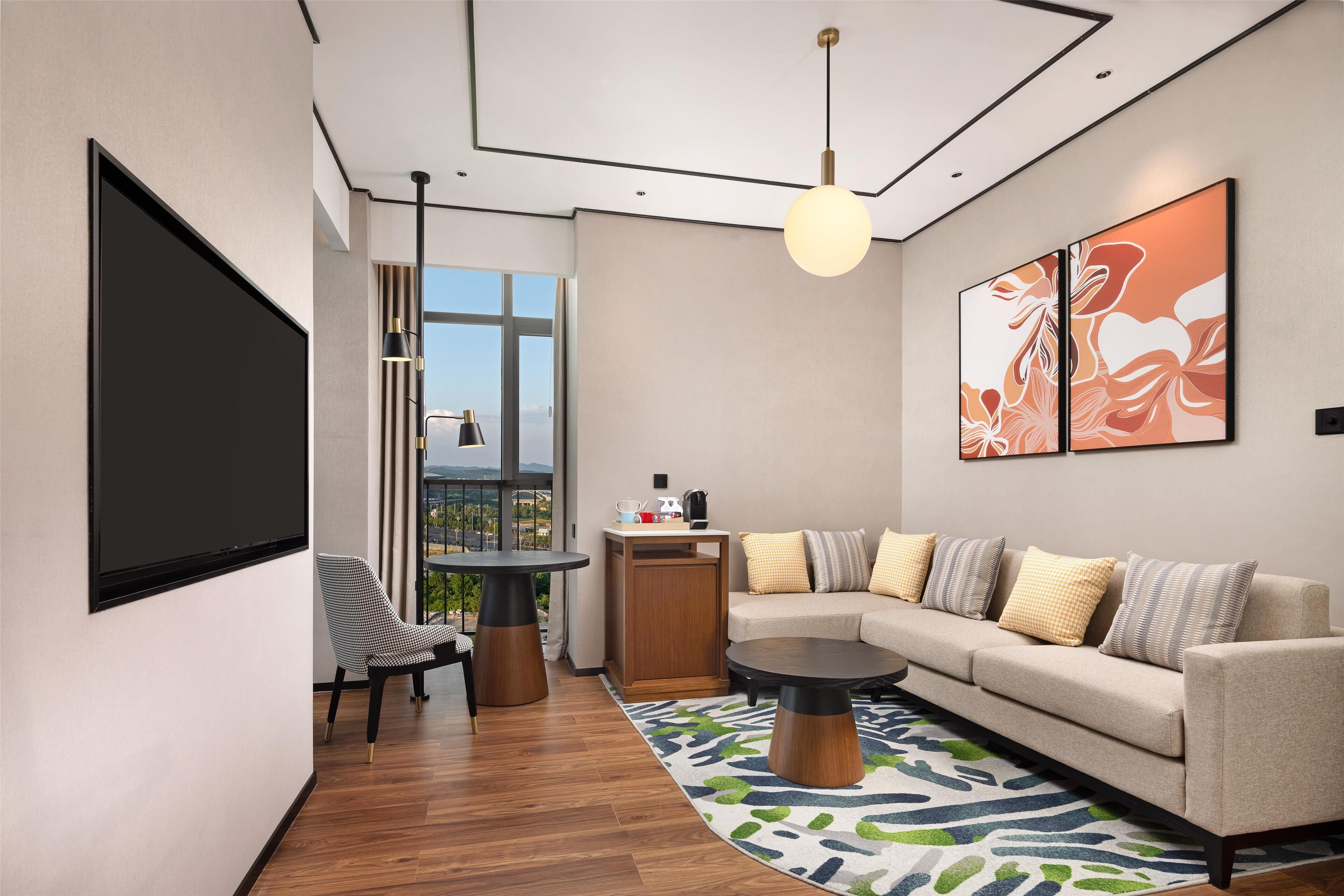 A modern living room with a sofa, coffee table, and a TV screen.