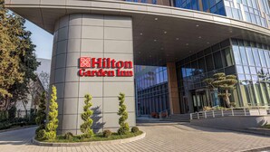 L’extérieur de l’hôtel Hilton Garden Inn se distingue par sa façade moderne en verre et son entrée imposante.