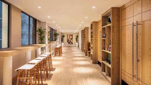 Une cuisine moderne avec des meubles en bois, un long plan de travail et des tabourets de bar.