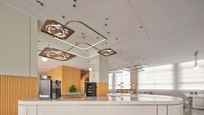 Un hall d’hôtel moderne doté d’un îlot central, de lambris en bois et de luminaires contemporains.