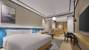 Une chambre d’hôtel moderne, dotée d’un grand lit, d’un bureau et d’une chaise.